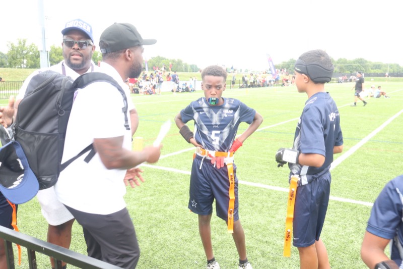 Coaches working with athletes on the field